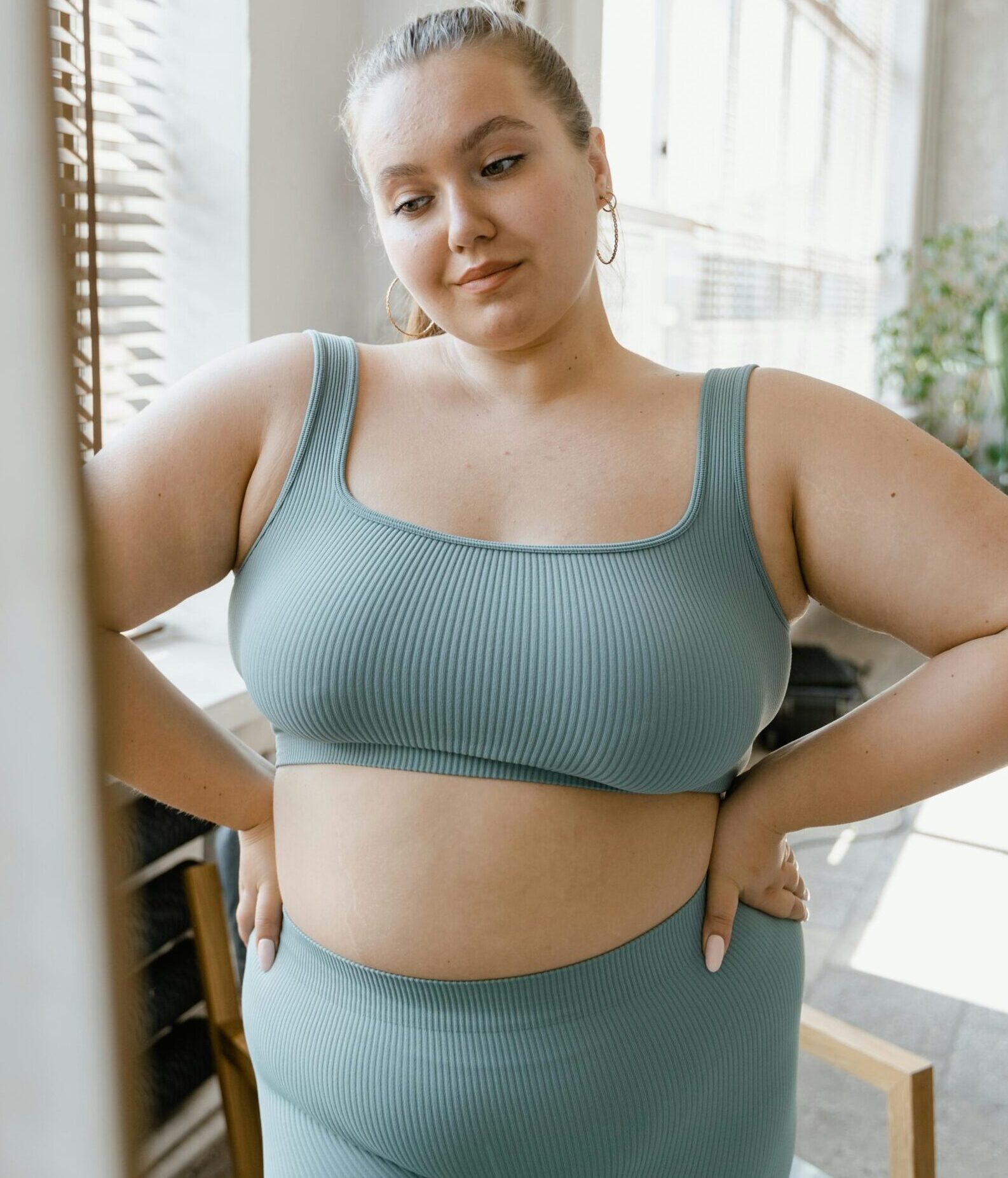 Woman in Teal Sports Bra and Brown Leggings